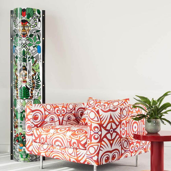 Slamp Stehleuchte Lafrique Extra Large Tube Schwarz neben buntem Sessel und Tisch, modernes Wohnzimmerdesign.
