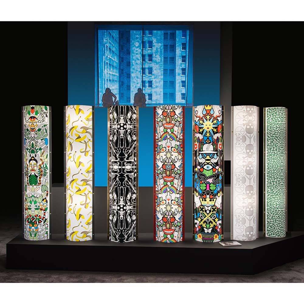 Slamp Stehleuchte Lafrique Extra Large Tube Schwarz in einem Ausstellungsbereich mit bunten Designs.