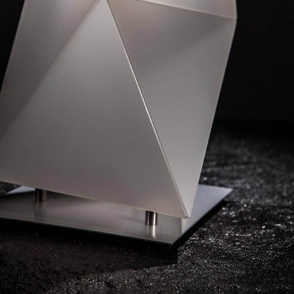 Slamp Tischleuchte Diamond Small Weiß auf einer dunklen Oberfläche, mit geometrischem Design und klaren Linien.