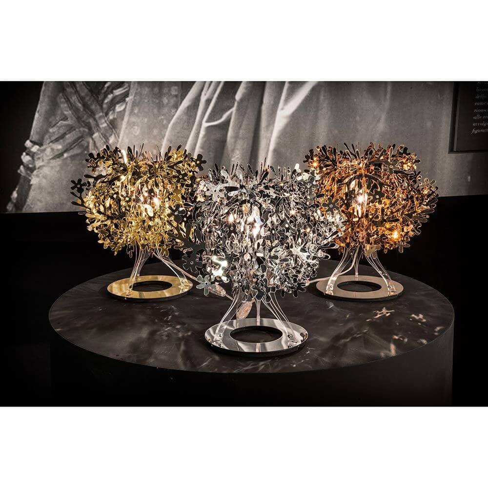 Slamp Tischleuchte Fiorella 370lm 2800K Weiß - stilvolle Tischleuchten in Gold, Silber und Bronze auf einem Tisch.