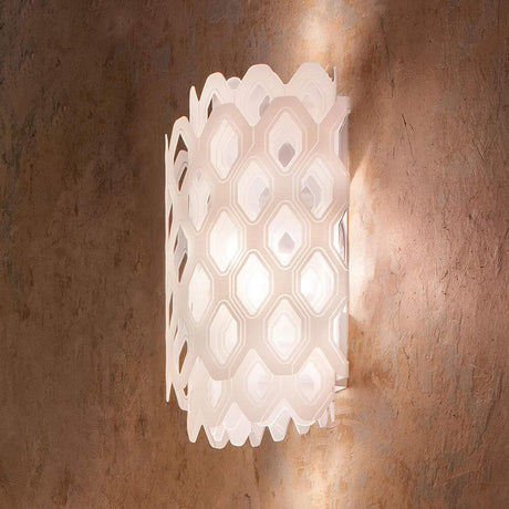 Slamp Wandlampe Charlotte Applique Weiß an einer Wand, mit wabenförmiger Struktur und sanftem Lichtspiel.