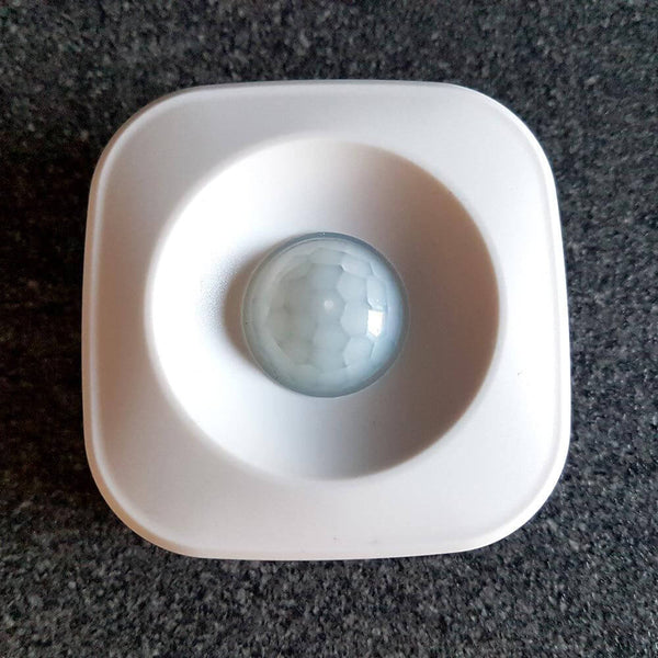 Capteur de mouvement Smart Mesh avec lentille ronde sur un boîtier blanc, idéal pour les réseaux d’éclairage.