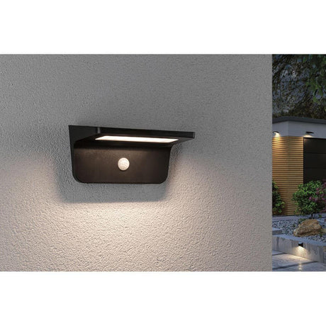 Solar LED sensor outdoor wall lamp Cyrus with orientation light mounted on an exterior wall.