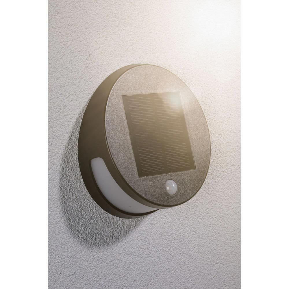 Solar LED Außenwandleuchte Helena Bewegungssensor Anthrazit an Wand montiert, mit Solarpanel und Bewegungsmelder.