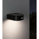 Solar LED Außenwandleuchte Eileen Sensor Schwarz an einer Wand mit warmweißem Licht.