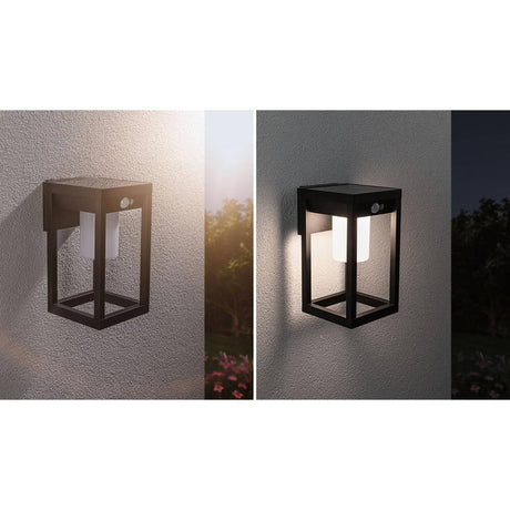 Solar LED outdoor wall light Marisol with motion sensor Black on a wall, emitted lighting in darkness.