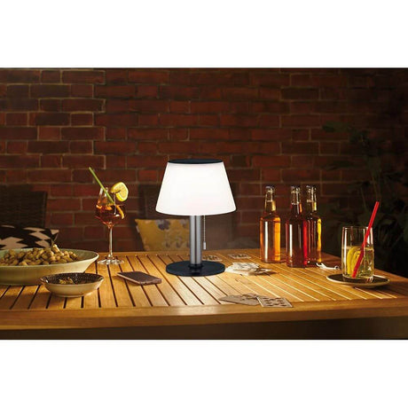 Solar LED Tischleuchte Lillesol Edelstahl mit Stufen-Dimmer auf einem Tisch im Freien, gemütliches Licht mit Getränken.