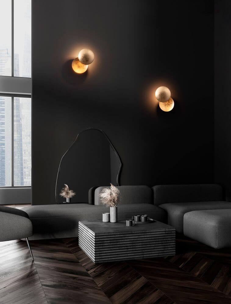 Solei LED Wandleuchte Ø 20cm 3000K an einer dunklen Wand über einem modernen Wohnzimmer-Setup.