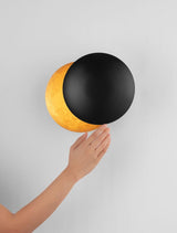 Solei LED Wandleuchte Ø 20cm in Schwarz und Gold, warmes Licht bei 3000K, elegant an der Wand montiert.
