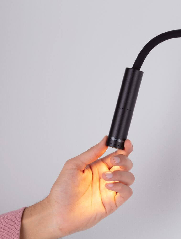 Sonica LED Wandleuchte Ø 8,5cm 3000K IP44 in der Hand eines Nutzers, leuchtend und elegant.