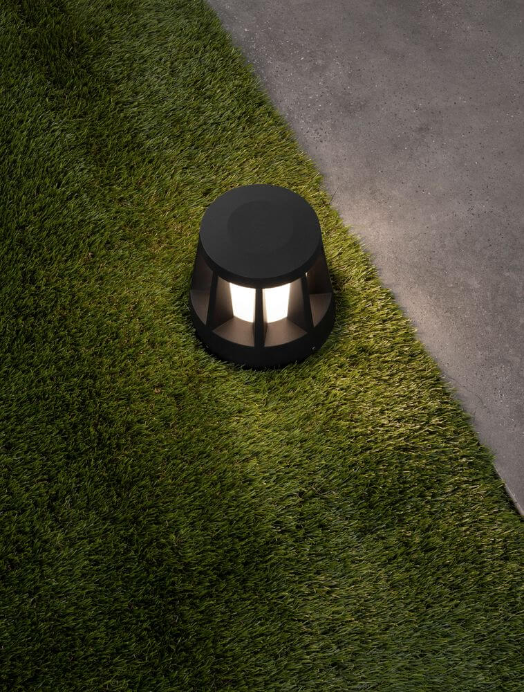 Stark LED Außensockelleuchte 3000K Anthrazit IP65 auf Gras und betoniertem Untergrund.