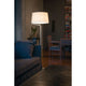 Stehlampe BERNI Weiß steht neben einem blauen Sofa in einem gemütlichen Wohnzimmer mit Bücherregal.