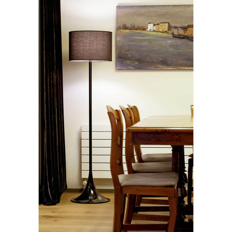 Stehlampe FARO Schwarz in einem hellen Raum mit Holzstuhl und Gemälde im Hintergrund.