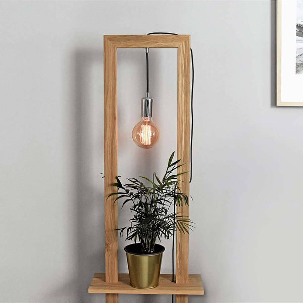 Stehlampe Monopod Eiche-Geölt mit einer Glühbirne und einer Pflanze in einem Topf.