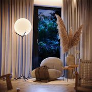 s.luce Orb Poseidon floor lamp with glass globe 175cm in a stylish living room with natural decor.