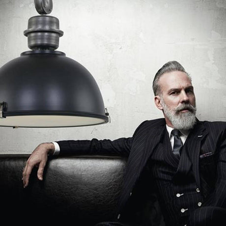 Industrial pendant light Bikkel Ø 52cm above a stylishly dressed man on a couch.