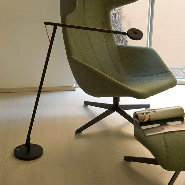 Rotaliana String LED floor lamp with Push Dimm to Warm Silver next to a modern armchair in a stylish room