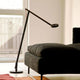 Moderne Rotaliana String LED-Stehleuchte mit elegantem, schwenkbarem Design neben einem Sofa.