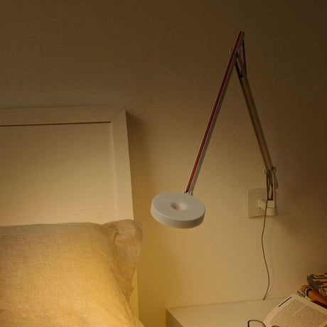Rotaliana String LED wall light with dimmer, black, in use next to a bed.