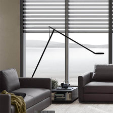 Rotaliana String XL LED-Stehleuchte mit Dimmer Schwarz-Orange in modernem Wohnraum mit Fenstern.