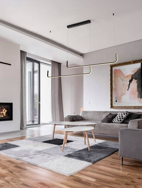 Suspension Strita LED 150 cm à 2 lumières 3000 K dans un salon moderne au-dessus d’une table.