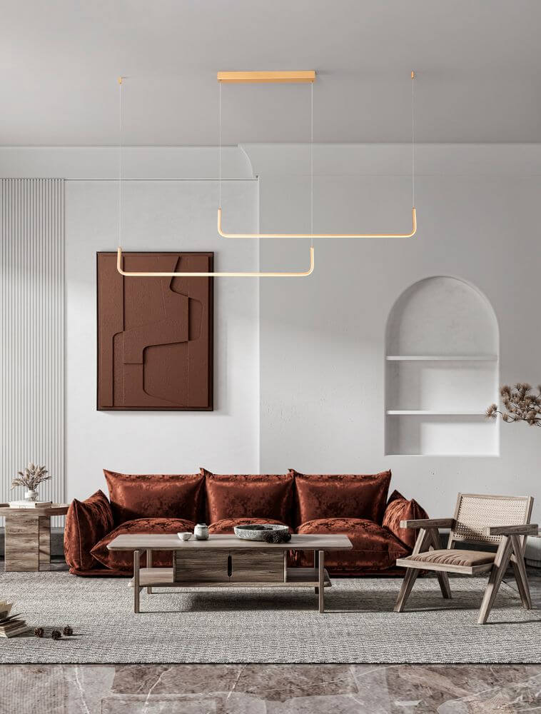 Strita LED Pendelleuchte 150cm 2-flammig 3000K in modernem Wohnzimmer mit brauner Couch und stilvollen Möbeln.