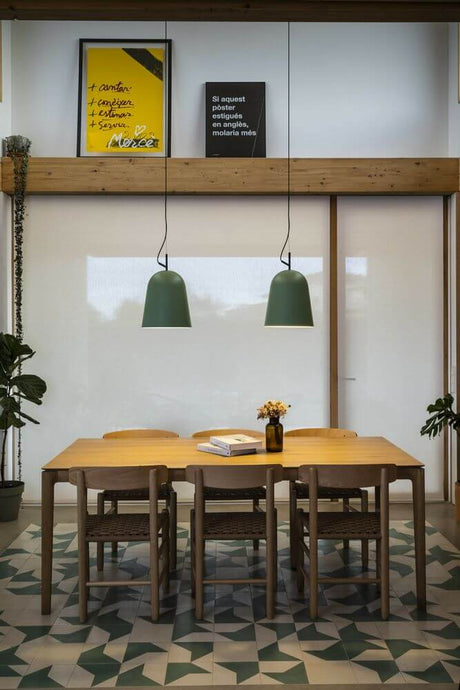 Modern interior with two green Studio pendant lights Ø 29cm above a dining table in a stylish room.