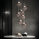 Lodes Kelly Cluster Sphere LED Pendellampe in metallischem Design, kreativ angeordnet über einem Tisch.