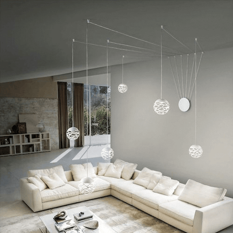 Lodes Kelly Cluster Sphere LED pendant lamp in a modern living space with an elegant sofa and sculptural lights.