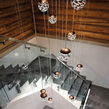 Moderne Kelly Cluster Kugelleuchte aus Metall, die über Treppe in hellem Raum hängt.