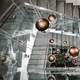 Lodes Kelly Cluster Sphere LED Pendellampe in modernem Treppenhaus-Design mit reflektierenden Oberflächen.
