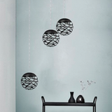 Lodes Kelly Cluster Sphere LED Pendellampe in skulpturalem Design, drei schwarze Kugelleuchten an einer Wand.