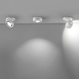 Drei Lodes Nautilus LED Deckenlampen in Weiß, drehbar und modern, strahlen gezieltes Licht auf eine Wand.