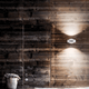 Lodes Nautilus LED Wandlampe 2300 Lumen an einer holzverkleideten Wand mit moderner Einrichtung