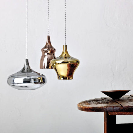 Lodes Nostalgia Glass Large 28cm LED pendellampe i krom, bronse og gull over et rustikt bord.