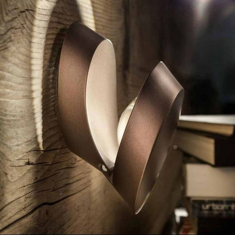 Lodes Pin-Up LED adjustable wall lamp on a wood-like wall, modern design with two LED light sources.