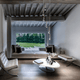 Modernes Wohnzimmer mit Lodes Rain LED Hängelampe, eleganten Möbeln und Blick ins Grüne.