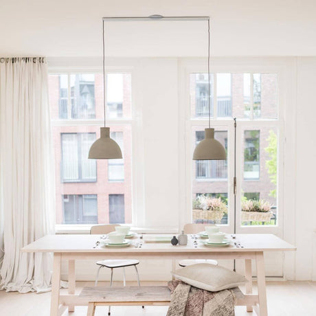Swing 2 hængesystem 90cm Twin til to hængelamper over et spisebord med stilfulde lamper.