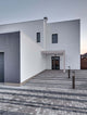 Moderne Architektur eines Hauses mit stilvollem Eingangsbereich und Pflasterstein-Parkplatz.