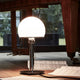Tecnolumen Wilhelm Wagenfeld Bauhaus-bordlampe WA23SW svart på et bord med musikknoter.