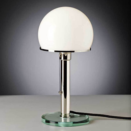Tecnolumen Bauhaus-bordlampe WG25GL Wilhelm Wagenfeld metall på et bord med rund glassplate.
