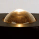 Nahaufnahme der goldenen Kuppel der Tecnolumen Egyptian Eye Bodenlampe auf schwarzem Untergrund.