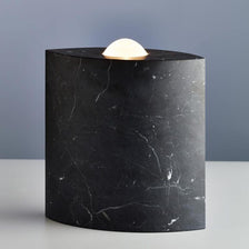 Tecnolumen Bodenleuchte Egyptian Eye Marmor Schwarz-Poliert auf einem Tisch mit eleganter Beleuchtung.