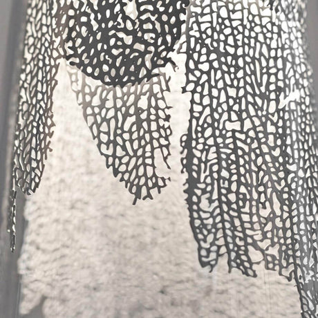 Detail view of the Terzani Frame design pendant light with a delicate metal coral leaf and borosilicate glass.