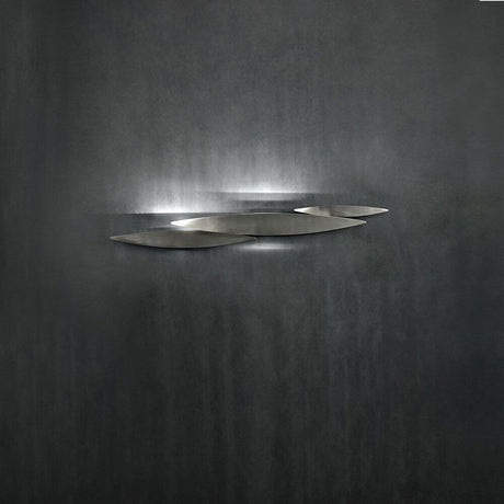 Terzani I Lucci Argentati LED Design-Wandlampe an einer dunklen Wand, einzigartiges Lichterlebnis.