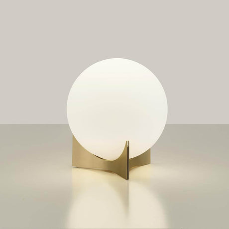 Terzani Oscar design table lamp with a round glass light on a gold-colored base.