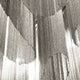 Detailansicht der Terzani Stream Design-Stehlampe mit metallic glänzenden Ketten und einzigartigem Lichtdesign.