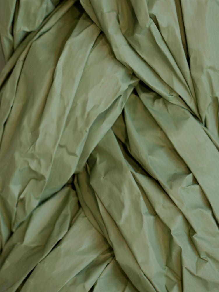 Faltiges, handgefertigtes Papier in sanftem Grün, ideal für kreative Lichtgestaltung.