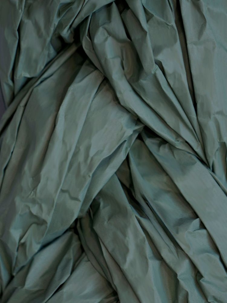 Struktur eines gefalteten, teils zerknitterten grünen Stoffes, ideal für textile Design-Projekte.