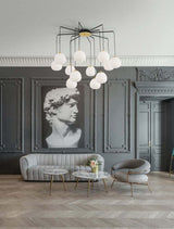 Moderne 12-flammige Pendelleuchte THE EGG in elegantem Wohnambiente mit opalen Glasschirmen und stilvollem Interieur.
